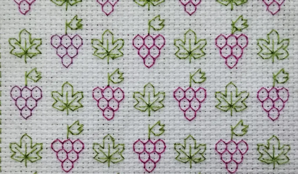 Bordado blackork a mano a color de un patron de uvas
