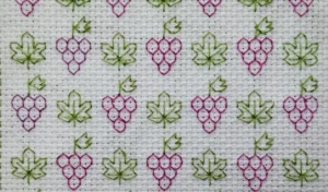 Bordado blackork a mano a color de un patron de uvas