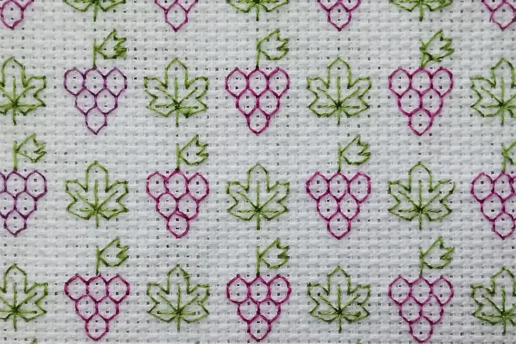 Bordado blackork a mano a color de un patron de uvas
